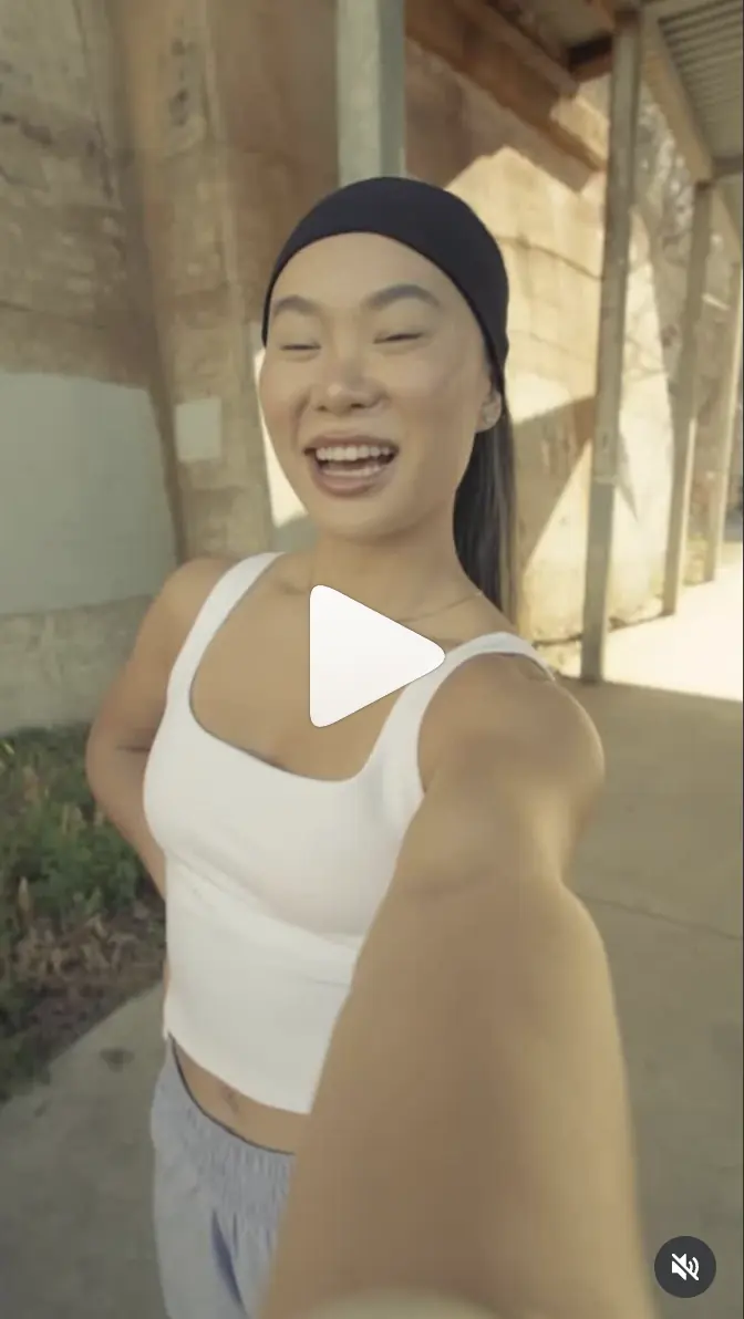 Balega ad: Lizzie smiling at the camera in a white tank and black headband.