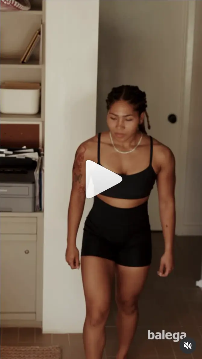Balega ad: a woman in black activewear walking through a hallway.